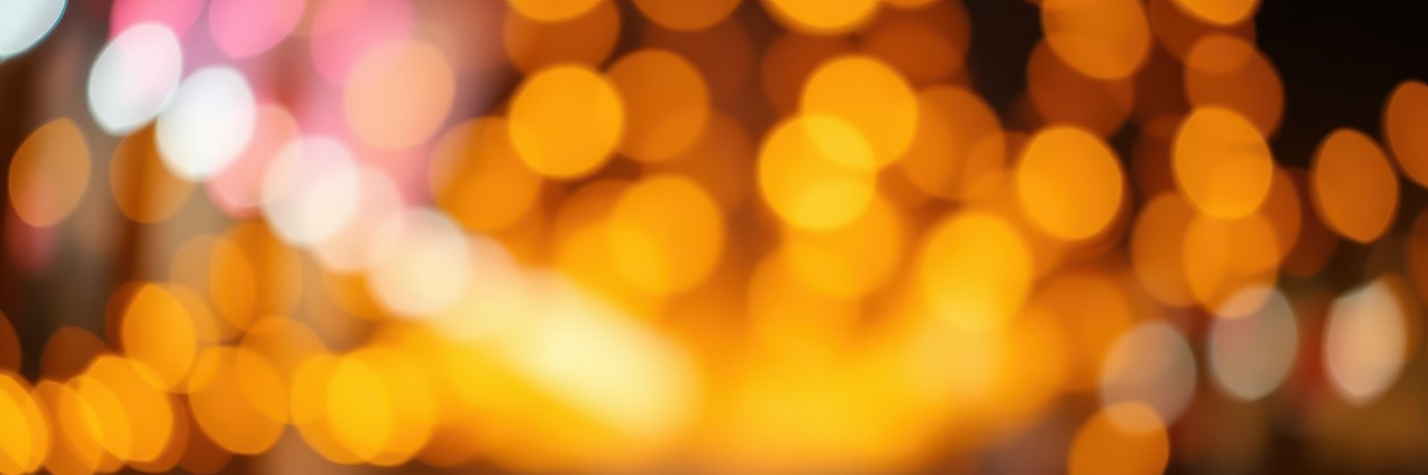 Vibrant bokeh lights create a warm atmosphere during an evening gathering in a bustling city setting